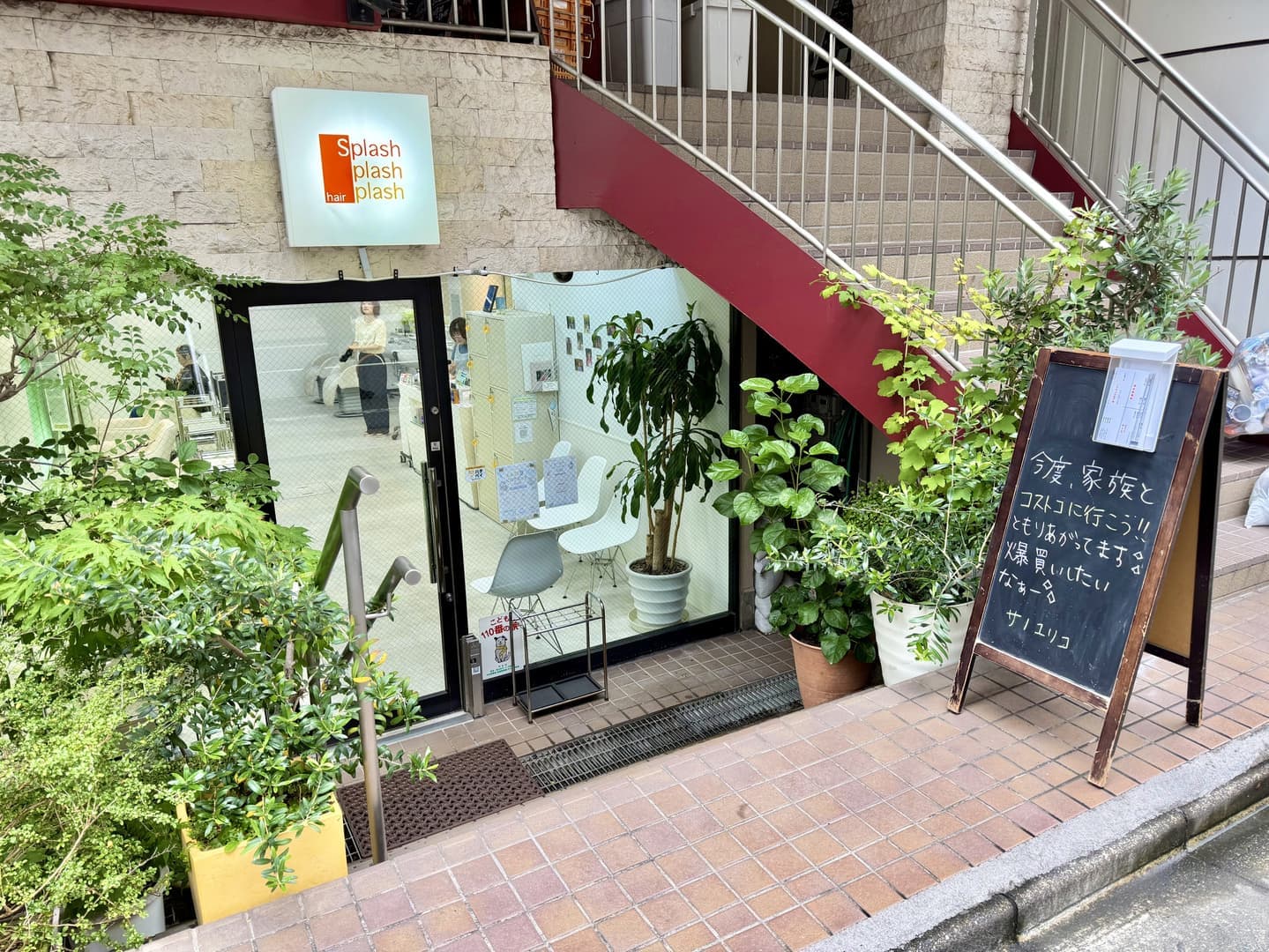 代々木八幡の美容室スプラッシュの緑豊かな入り口とスタッフからのメッセージが書かれた黒板の写真。