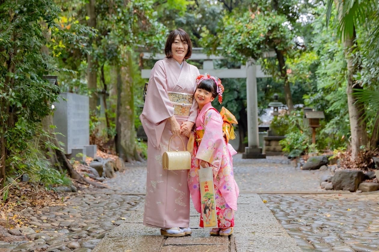 代々木八幡宮の鳥居前の参道で七五三写真を撮影している７歳の女の子と和服姿のママの写真