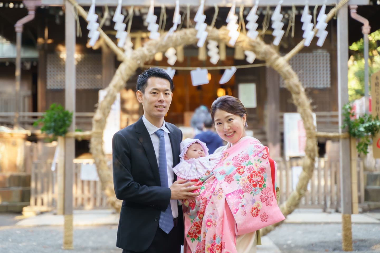 代々木八幡宮でのお宮参りの写真。パパとママに抱っこされた赤ちゃんが可愛いです。｜美容室スプラッシュ