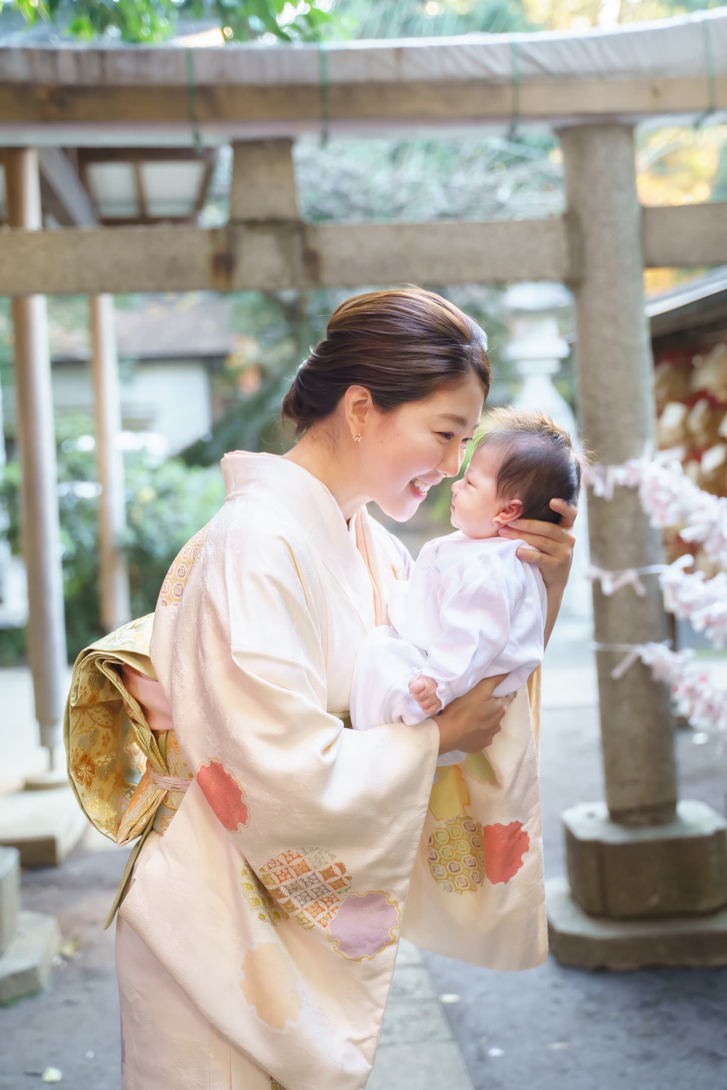 代々木八幡宮のお宮参りで着物姿のママが赤ちゃんを抱っこして見つめている写真｜美容室スプラッシュ