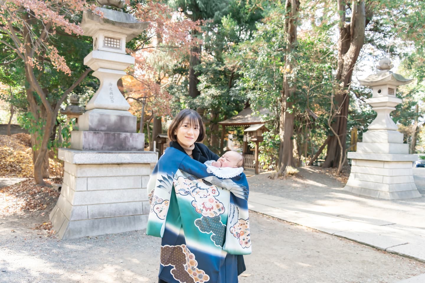 お宮参りのご祈祷の時に、代々木八幡宮の境内で赤ちゃんを抱っこしているママの写真｜美容室スプラッシュ