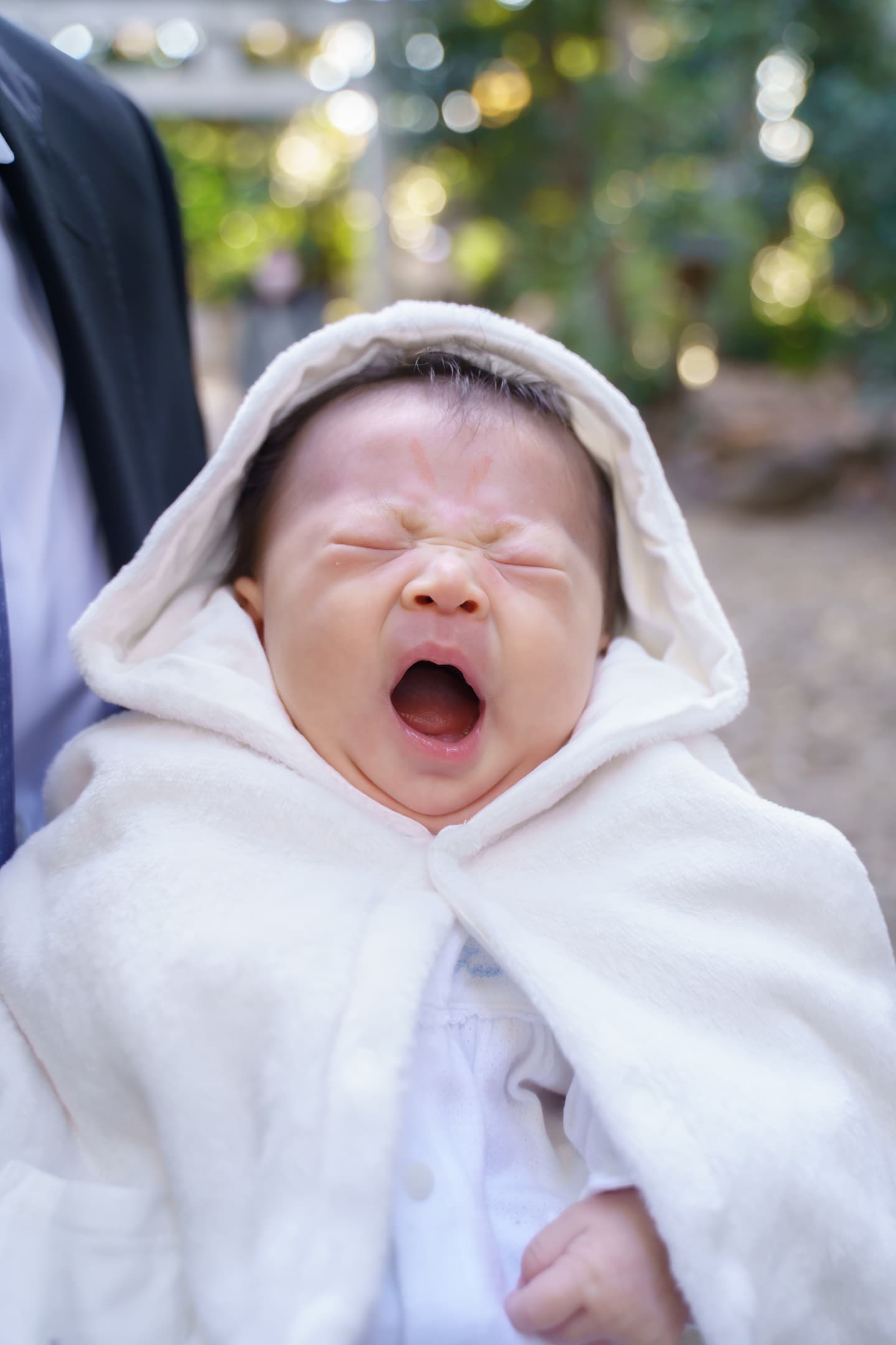 代々木八幡宮のお宮参りの後、大きなあくびをしている赤ちゃんの写真｜美容室スプラッシュ
