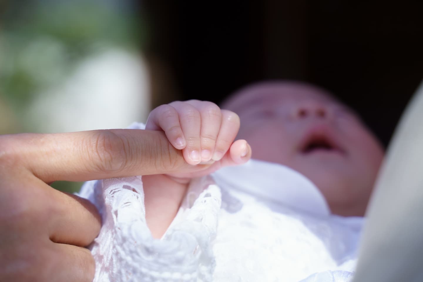 代々木八幡宮のお宮参りで赤ちゃんがママの指をしっかり掴んでいる写真｜美容室スプラッシュ